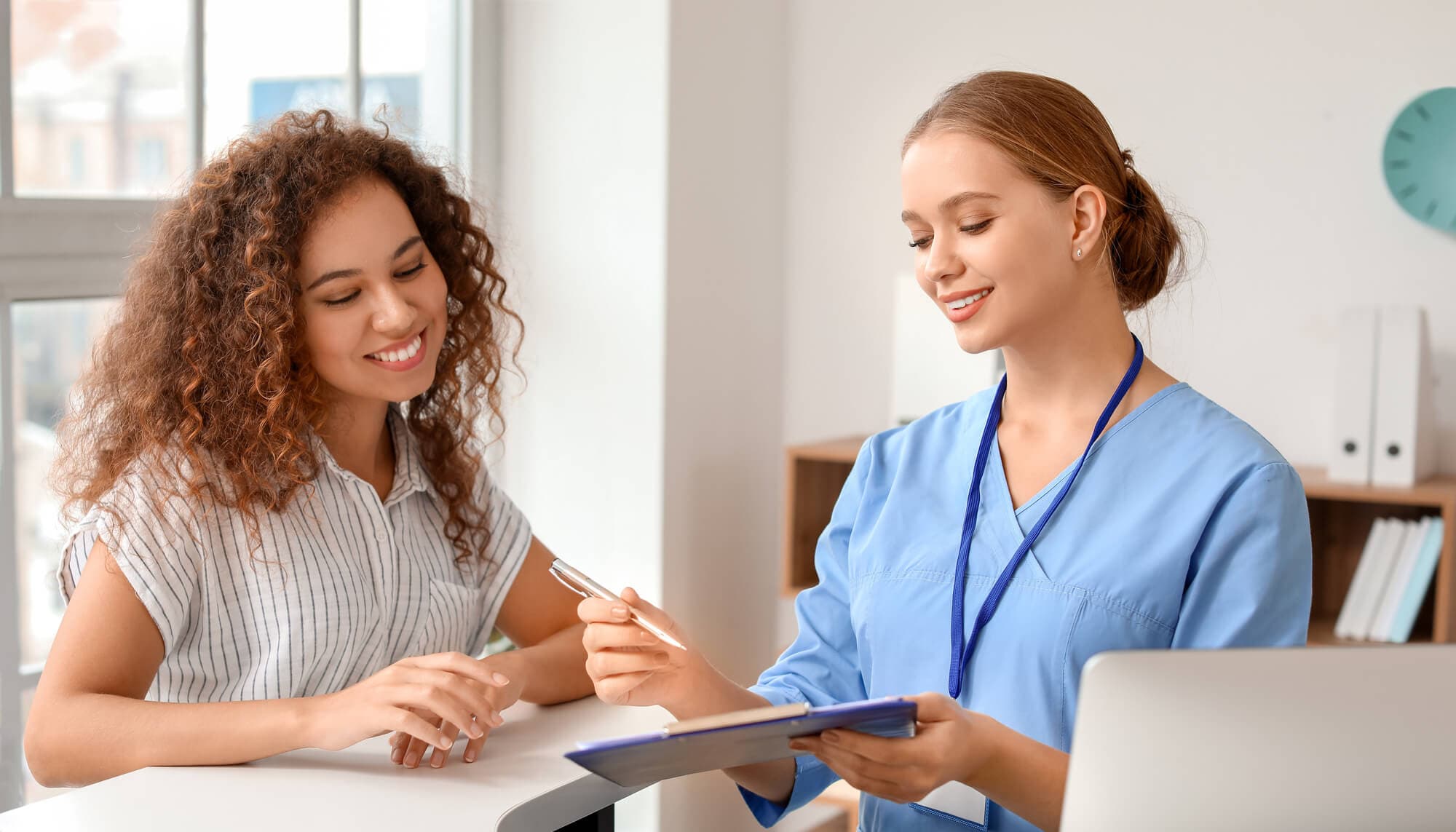 Front desk staff welcoming patients at a Dr.NYC office